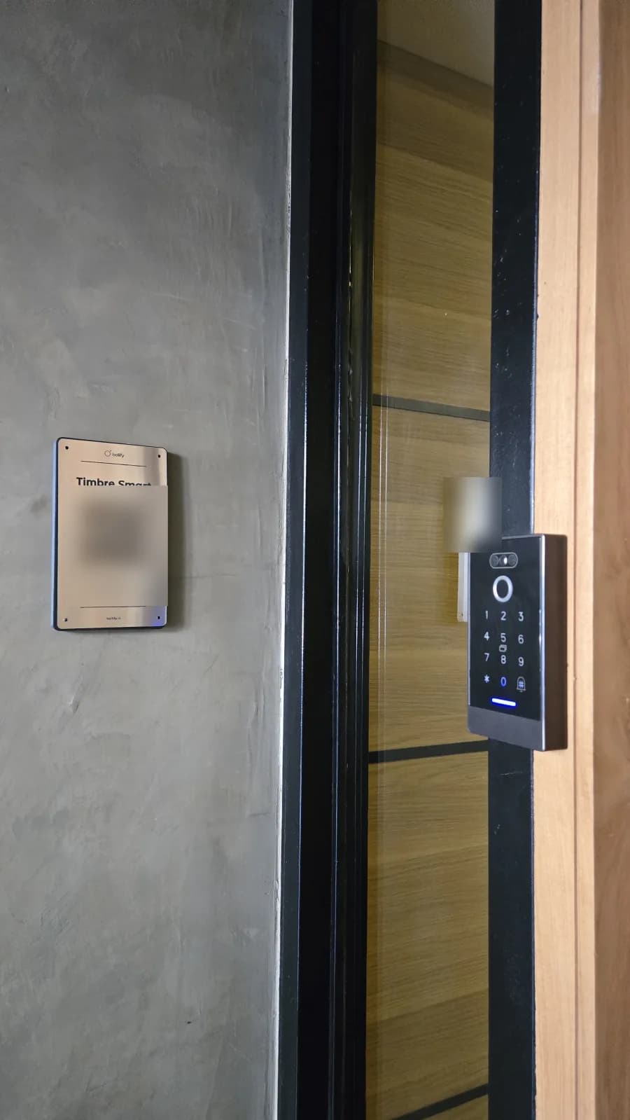 Placa QR de Bellify junto al control de acceso digital en la entrada de un edificio